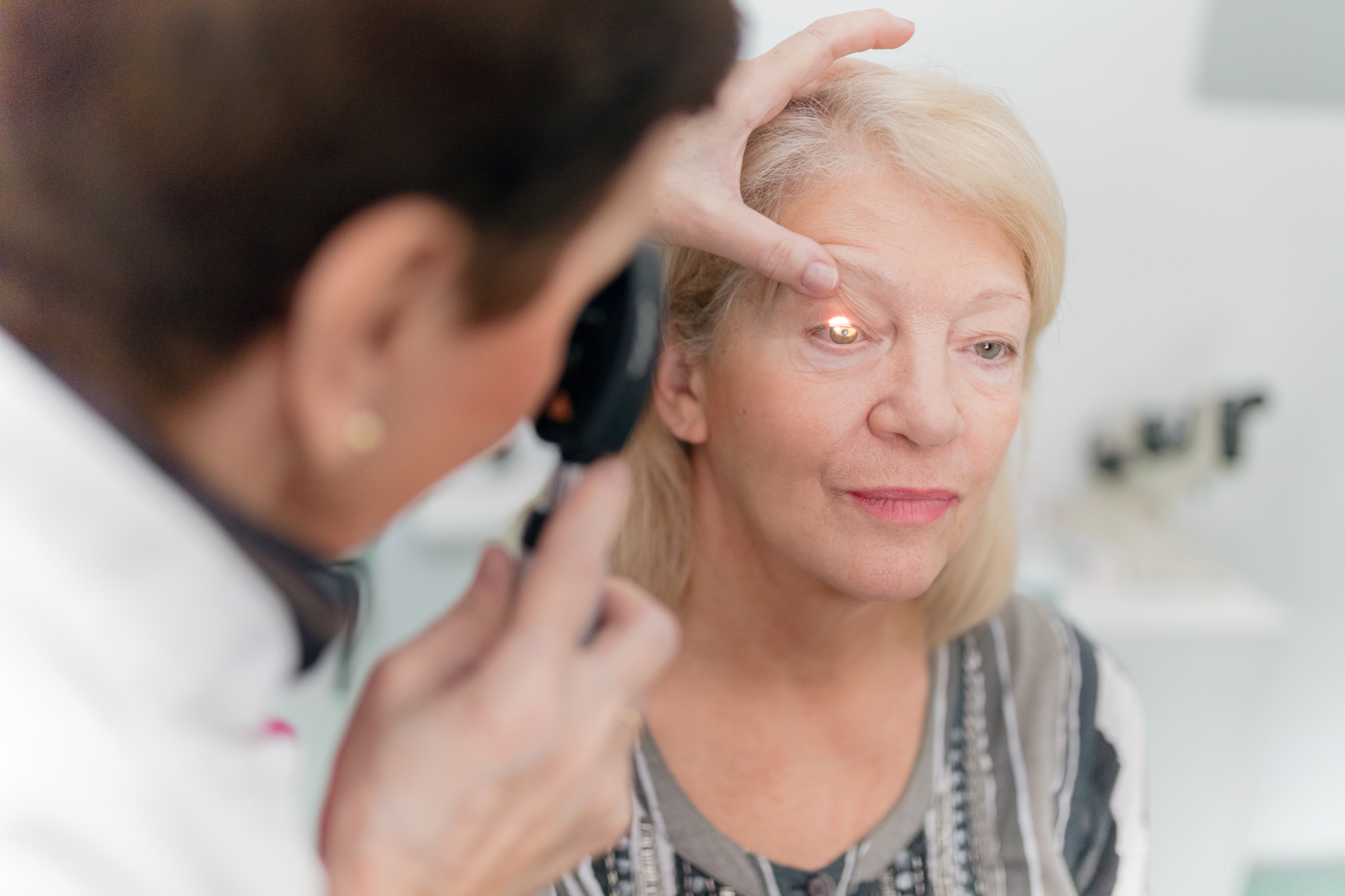 Elderly woman with glaucoma receiving eye exam