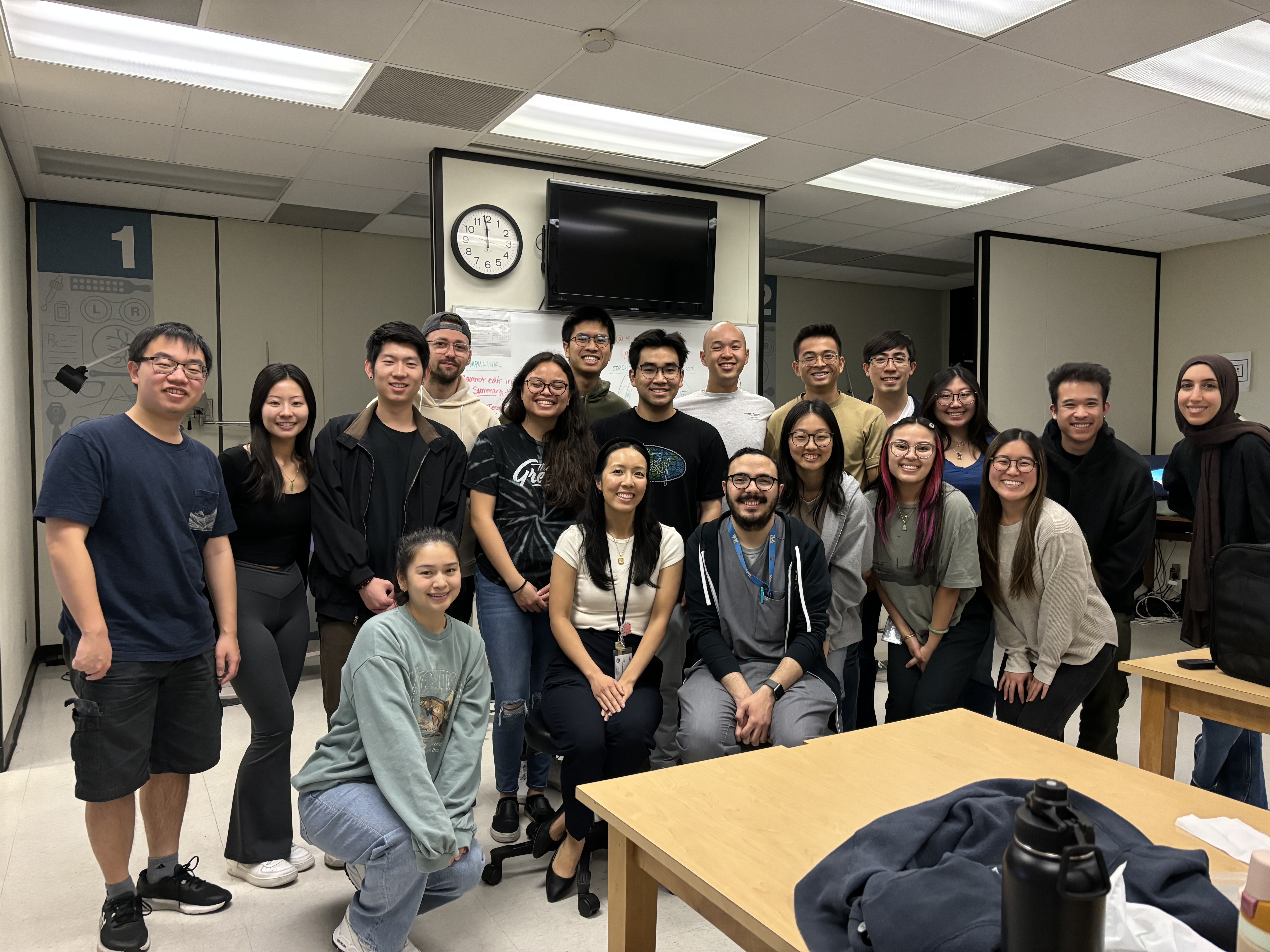 A photo of students standing together and smiling in a classroom.