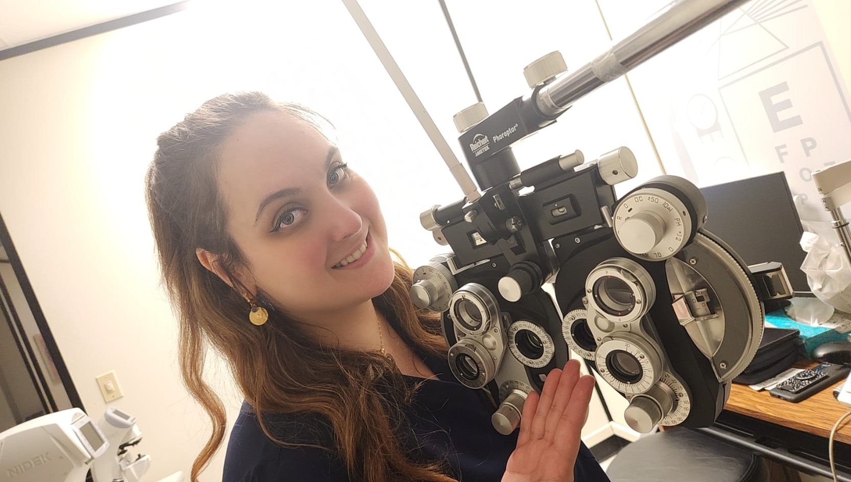 Student smiling while using optometry equipment.